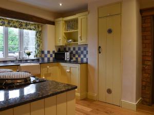 uma cozinha com armários amarelos e um balcão preto em Barnscliff Heights em Broxa
