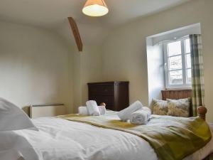 a bedroom with a large white bed with towels on it at Barnscliff Heights in Broxa