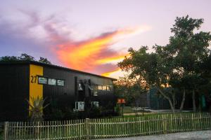 a house with a fence and a cloudy sky at SleepOver Orpen Gate in Acornhoek