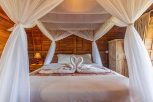 een slaapkamer met 2 zwanenhanddoeken op een bed bij D'jineng Rice Terrace Canggu in Canggu