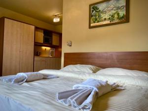 a bedroom with two beds with towels on them at Holiday Resort Tatry in Veľká Lomnica