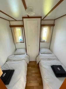 two beds in a small room with two windows at Chalet D12 - Camping it Soal in Workum