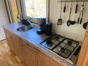 a kitchen counter with a stove and a sink at Chalet D12 - Camping it Soal in Workum
