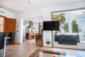 ein Wohnzimmer mit einem Flachbild-TV und einem Wohnzimmer in der Unterkunft Villa Athos - PlusHolidays in Calpe