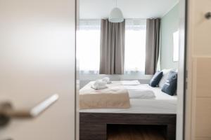 - une chambre avec un lit et un miroir dans l'établissement limehome Bremerhaven Kantstraße, à Bremerhaven