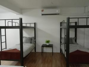 a bedroom with two bunk beds and a table at Doodle Lodge Bangkok in Bangkok
