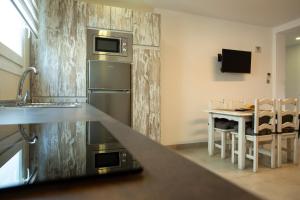 a kitchen with a stainless steel refrigerator and a table at Apartamentos Aponiente in Conil de la Frontera