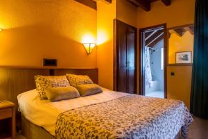 1 dormitorio con 1 cama con paredes amarillas en San Anton Benasque, en Benasque