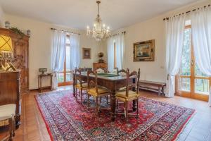 een eetkamer met een tafel en stoelen op een tapijt bij Villa Margherita by Wonderful Italy in Civenna