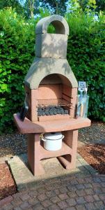 a brick oven sitting on top of a patio at [Veluwe] Chalet De Rode Vos, 2-6p 60m2! Gezinspark! in Voorthuizen