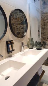 W łazience znajduje się biała umywalka i lustro. w obiekcie Finca La Suerte Grande w mieście Telde