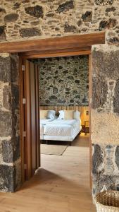 a bedroom with a bed in a stone wall at Finca La Suerte Grande in Telde