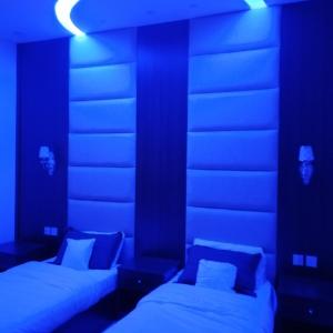 2 camas en una habitación con luces azules en شالية قاردن لايت, en Taif