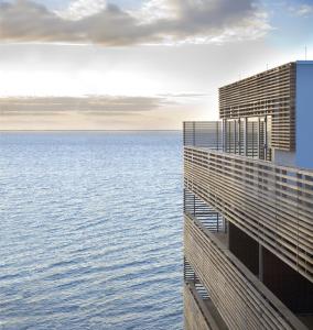 uma vista para o oceano a partir de um edifício em BUDERSAND Hotel - Golf & Spa - Sylt em Hörnum