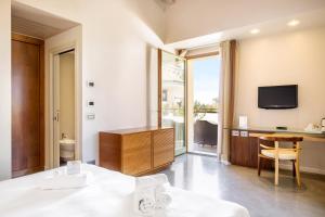 Cette chambre comprend un lit, un bureau et une télévision. dans l'établissement The Ziba Hotel & Spa, à Peschiera del Garda