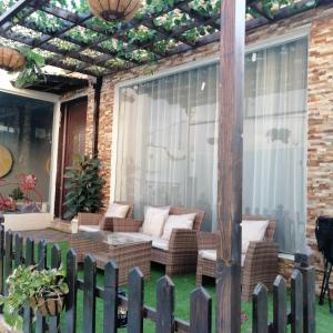 un patio con sillas de mimbre y pérgola en شالية قاردن لايت, en Taif