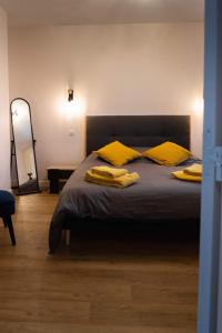 a bedroom with a bed with yellow pillows on it at La Ferme de Bacchus in Hautvillers