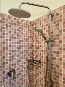 ein Bad mit einer Dusche und rosafarbenen Fliesen in der Unterkunft Domus Corso Umberto 18 B&B in Pescara