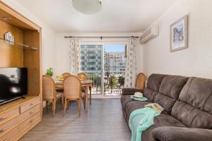 ein Wohnzimmer mit einem Sofa und einem Tisch in der Unterkunft Apartamento Arenal 6 - PlusHolidays in Calpe