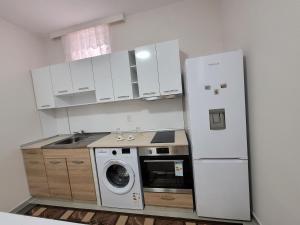 a kitchen with a refrigerator and a washing machine at Китанови- стаи за гости in Sliven