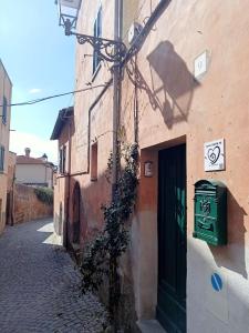un edificio con una puerta verde al lado de una calle en Casa Cencioni en Tuscania
