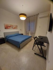 een slaapkamer met een blauw bed en een tafel bij Neapolis Apartment & Rooms in Siracusa