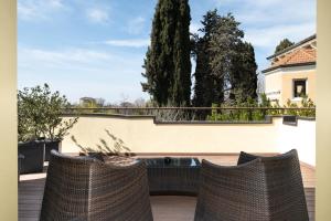 a patio with two rattan chairs on a balcony at The Ziba Hotel & Spa in Peschiera del Garda