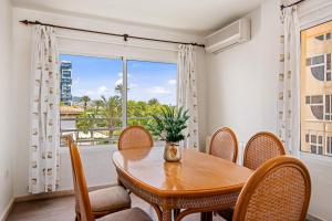 uma sala de jantar com uma mesa e cadeiras e uma janela em Apartamento Arenal 5 - PlusHolidays em Calpe