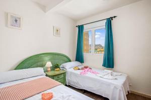 カルプにあるApartamento Arenal 5 - PlusHolidaysの小さなベッドルーム(ベッド2台、ベッドにベビードール付)