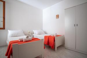 1 dormitorio con 2 camas y manta roja en Residence Via Milano, en Marina di Mancaversa