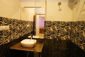 y baño con lavabo y espejo. en Brick Field en Varanasi