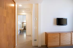 a living room with a television on a wall at The Ziba Hotel & Spa in Peschiera del Garda