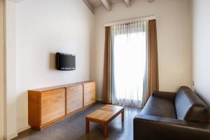 a living room with a couch and a tv at The Ziba Hotel & Spa in Peschiera del Garda