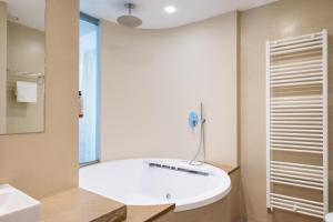 a bathroom with a white tub and a sink at The Ziba Hotel & Spa in Peschiera del Garda