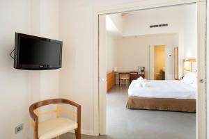 a bedroom with a bed and a tv on a wall at The Ziba Hotel & Spa in Peschiera del Garda