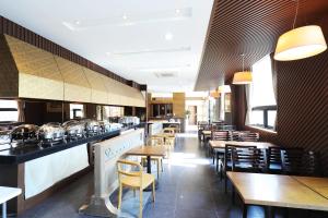 a restaurant with wooden tables and chairs and a bar at Incheon Wolmido Dubai Tourist Hotel in Incheon