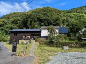 a building with a sign on the side of a road at 　Komori Village GH ～小森ヴィレッジ ゲストハウス～ 自然の中にある庭付平屋一棟貸 