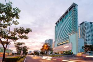 uma rua da cidade com um edifício alto e uma cidade em Olive Tree Hotel Penang em Bayan Lepas