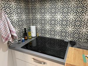 uma cozinha com uma parede em preto e branco em Villa Premium 3 étoiles sur Terrain clos de 300 M2 em Bagnols-sur-Cèze