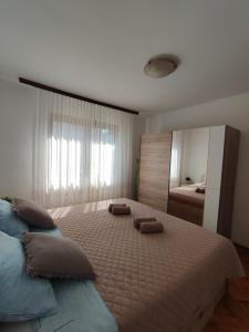 a bedroom with a large bed with two pillows on it at Apartment Jelena in Fažana
