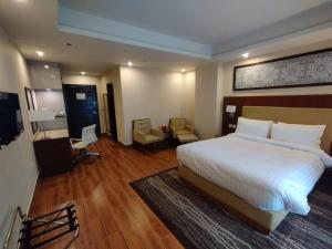 una camera d'albergo con letto, scrivania e sedia di Avari Xpress Gilgit a Gilgit