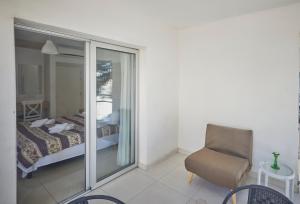 um quarto com uma cama, uma cadeira e uma janela em Napa Nest em Agia Napa