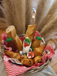 ein Korb mit verschiedenen Brotsorten und Apfelwein in der Unterkunft studio d'henri in Agen