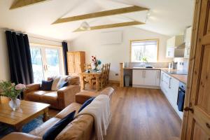 a living room with a couch and a kitchen at Pen Dragon - 2 Bedroom Cottage - Pen-Clawdd in Gowerton