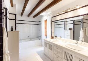 a white bathroom with two sinks and a bath tub at Finca Can Coll Boutique Country House - Adults Only in Sóller