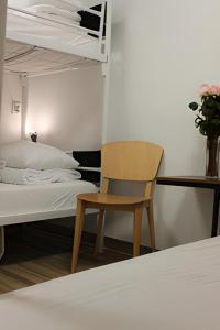 a bedroom with a bed and a chair next to a bunk bed at Warsaw Hostel Centrum in Warsaw