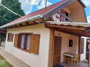 Casa pequeña con puertas de madera y mesa en Vár-Lak, en Borgáta
