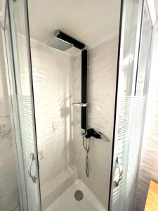 uma casa de banho com um chuveiro e uma porta de vidro em Olive Apartment City Center by thesbnb em Tessalônica