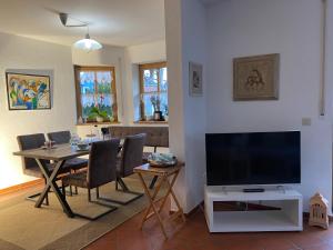 een woonkamer met een eettafel en een flatscreen-tv bij Ferienhaus Brühler in Maierhof