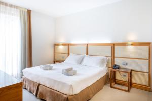 a hotel room with a large bed with two white pillows at The Ziba Hotel & Spa in Peschiera del Garda